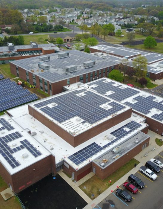 Aerial view of industrial building with solar panels on roof