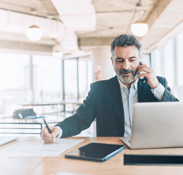 Man talking on the phone and working on a computer