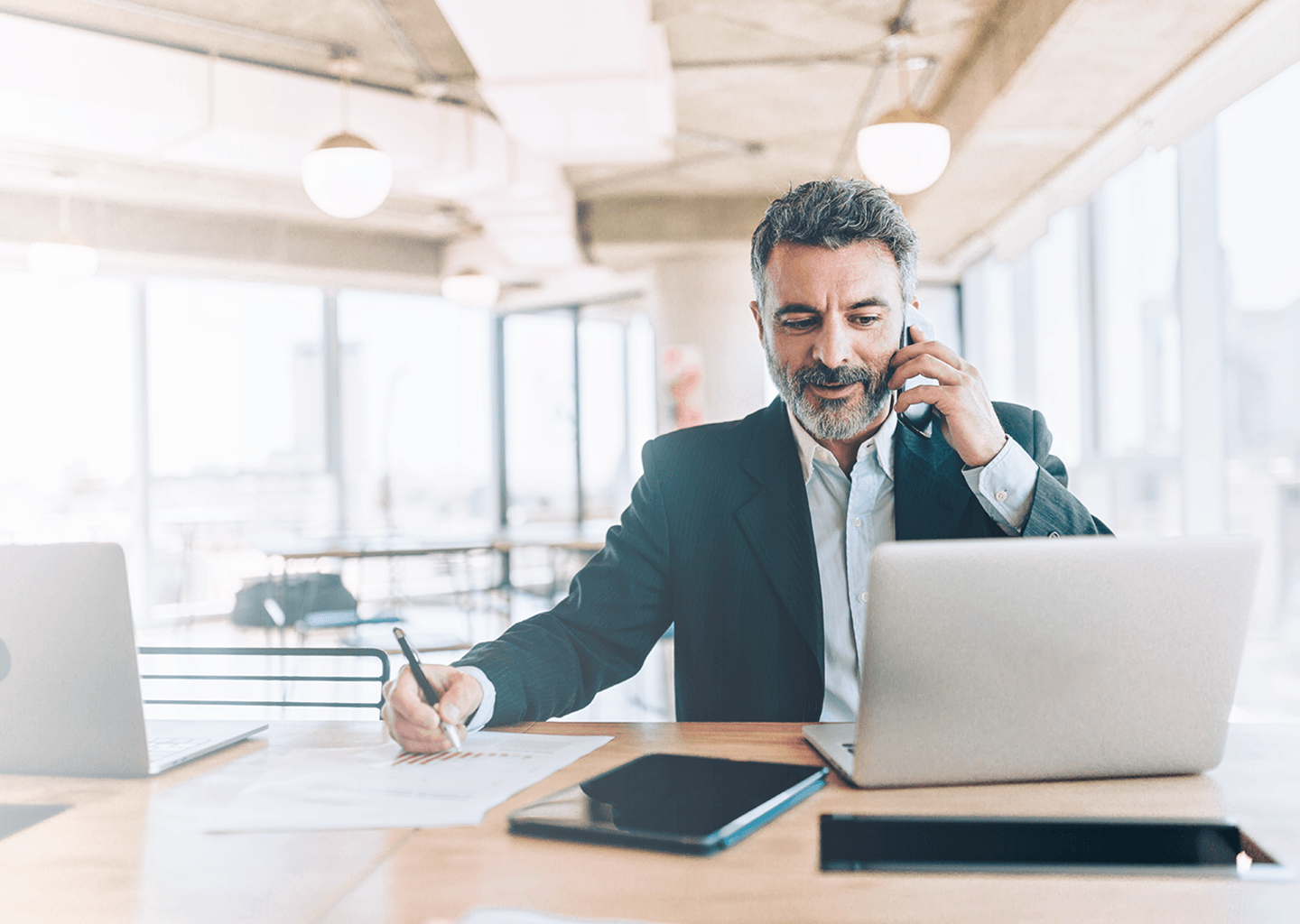 Man talking on the phone and working on a computer