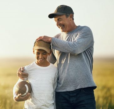 Father and son playing football on an open field