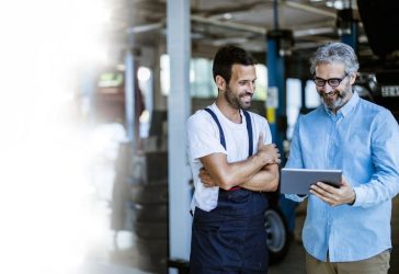 Man talking to mechanic in garage