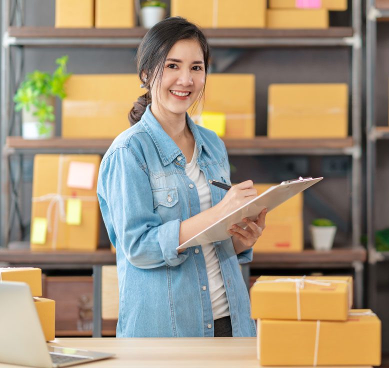 Young lady writing on clip board in small business
