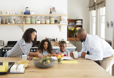 Young black family busy together in their kitchen