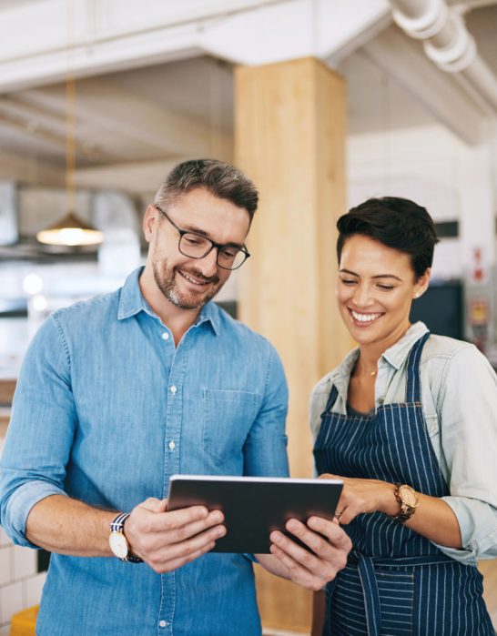 man and woman looking at a tablet in a restaurant