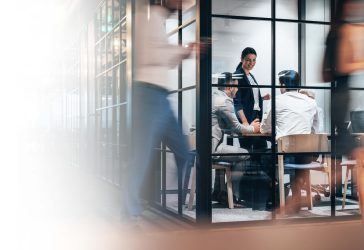 Busy workplace and meeting in a glass office