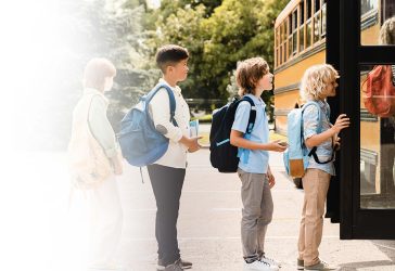 A line of children waiting to get on the school bus