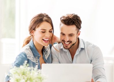 happy couple looking at laptop