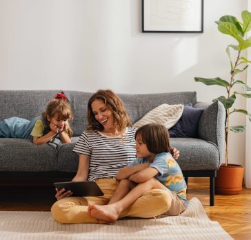 mom and daughters looking at ipad