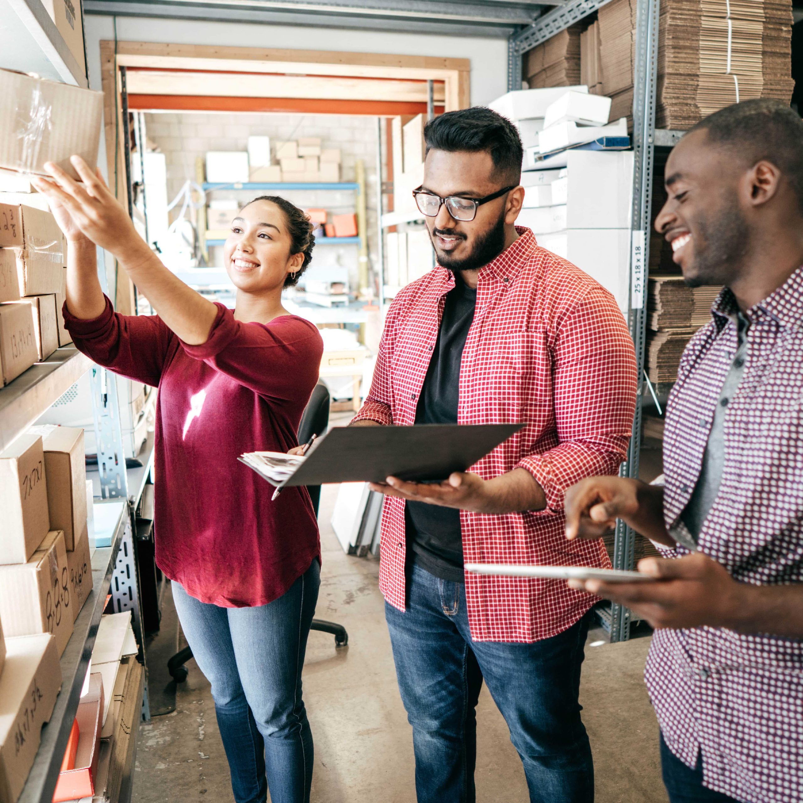 Group of adults pulling inventory in back room of business