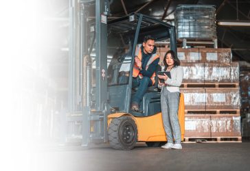 Man on Forklift talking with lady with a clipboard