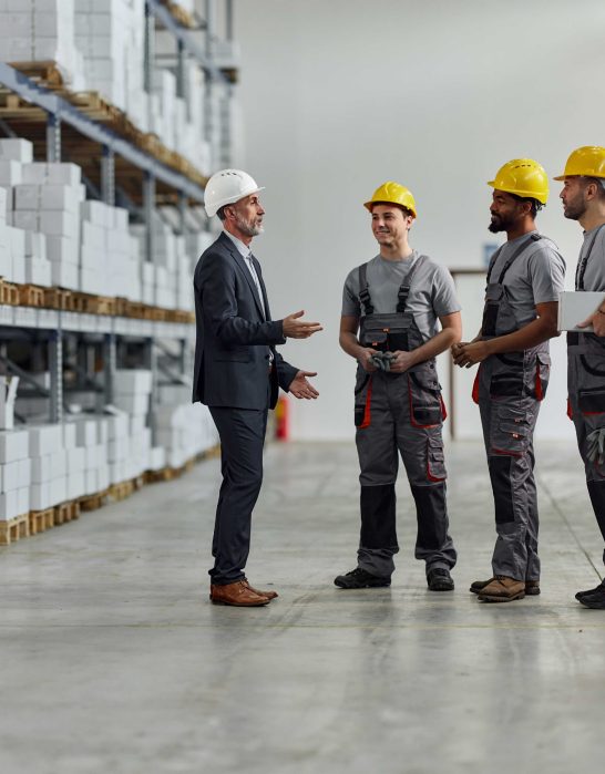 Supervisor talking with group of employees in warehouse