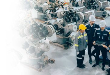 Group of factory workers meeting in front of machinery