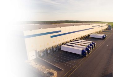 Semi trucks lined at a warehouse