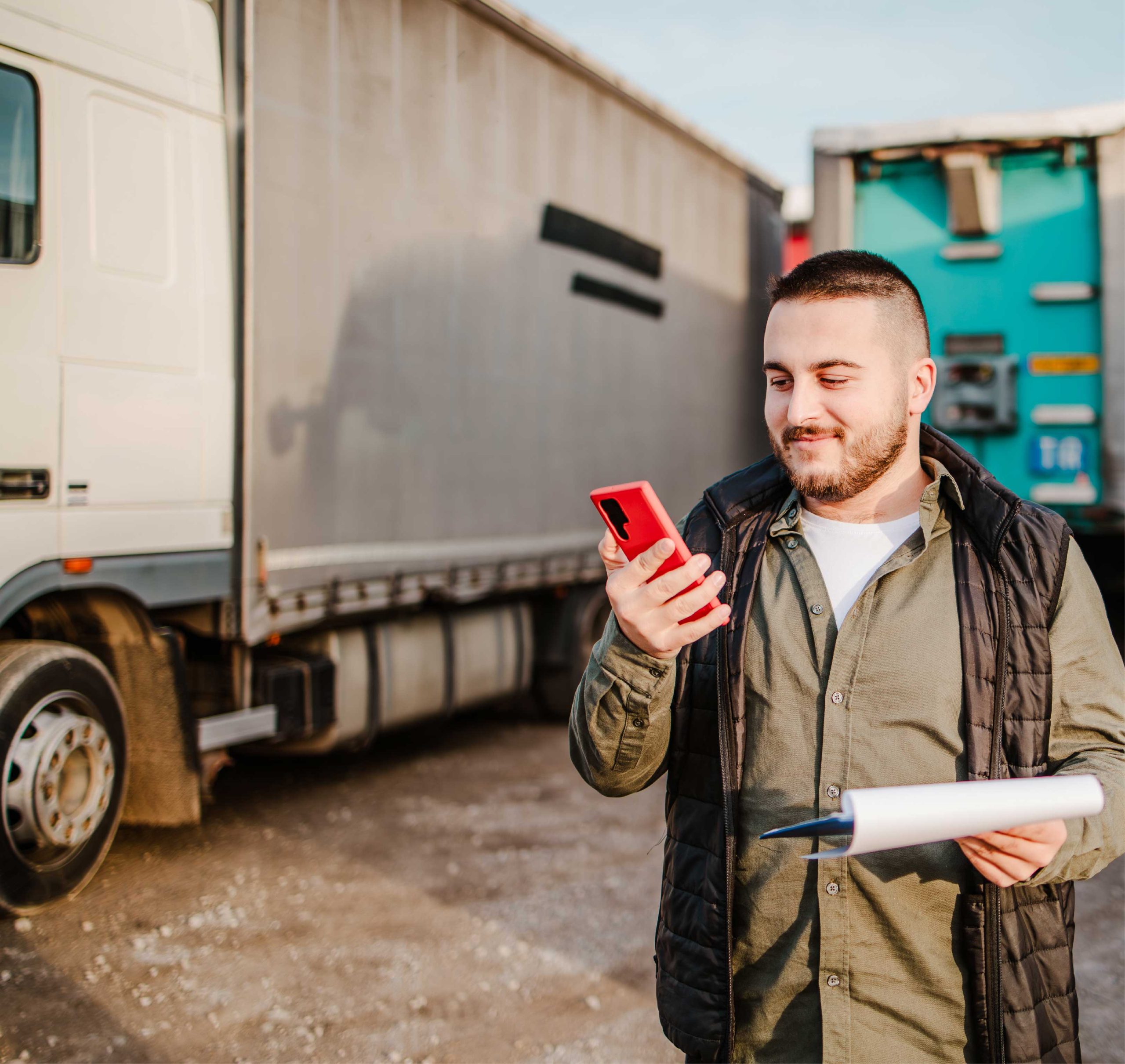 Man infront of semi truck looking at phone