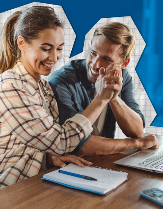 Couple high-fiving over a computer and notebook.